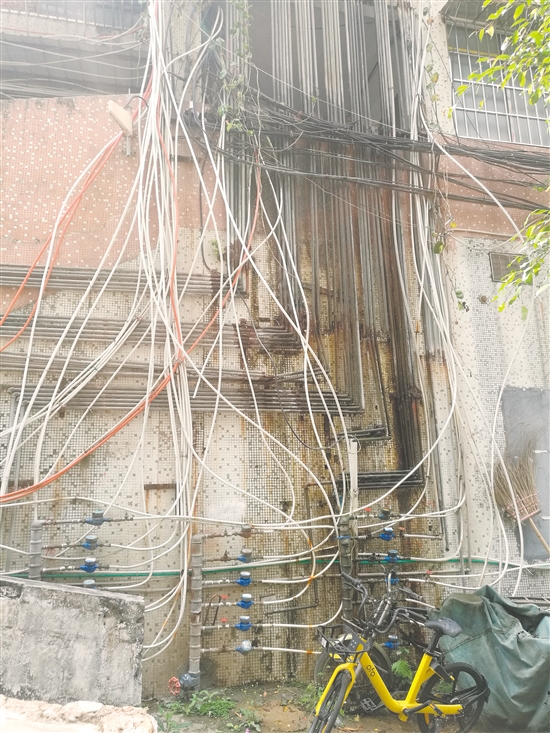 良化西44—46号居民楼楼下错落的自来水管一直延伸到楼上，形成一挂“水管瀑布”。